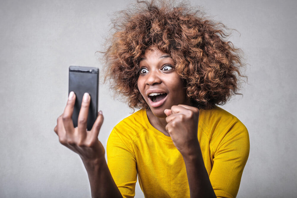 Woman looking at her phone - surprised to learn about digital marketing tools
