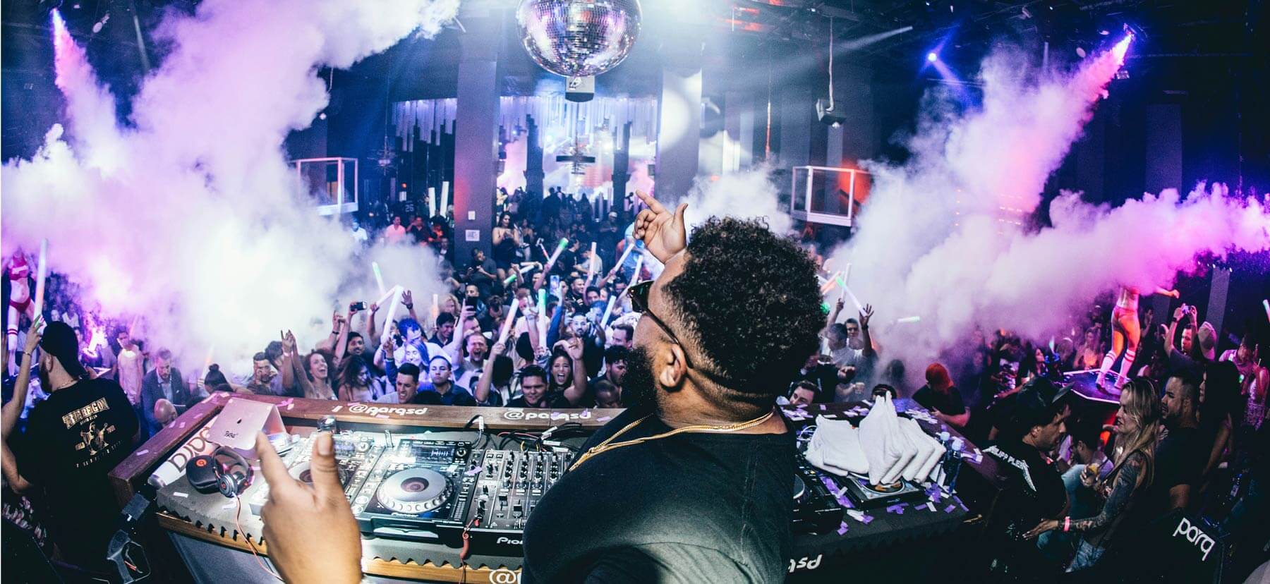 Photo of a DJ music brand playing a live event with fog blasting into the air